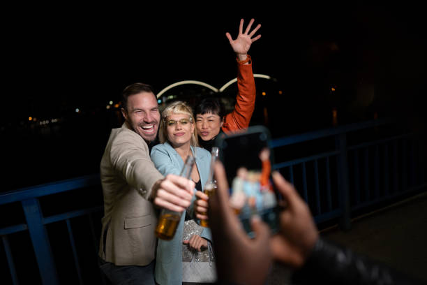 istock Friends celebrating on a night out, using mobile phone. 2200345698