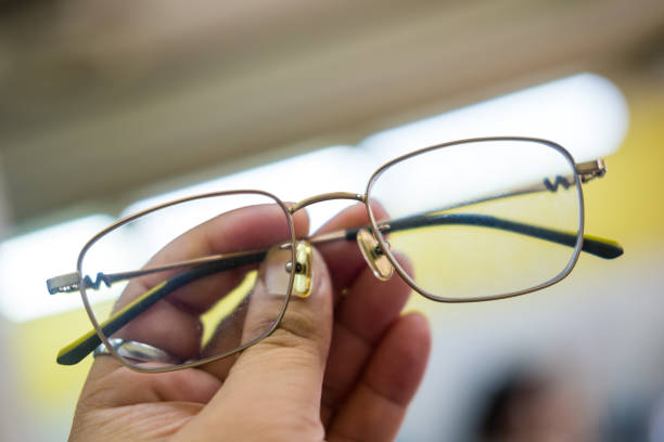 istock Man holding glasses with round metal frame. 2200346021
