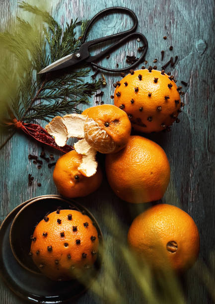 Three yellow tangerines against the background of a Christmas tree light garland