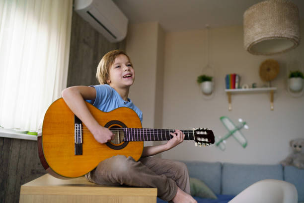 istock Carefree boy playing guitar and singing 2200346963