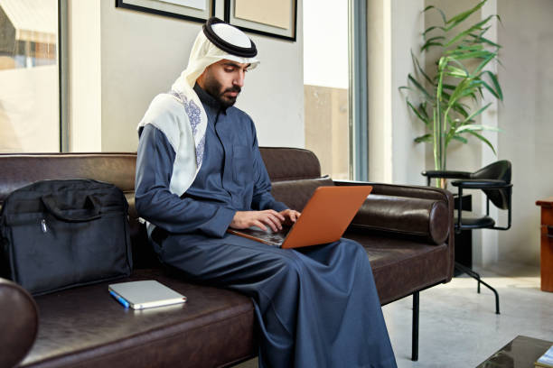istock Young Saudi businessman using laptop in coworking office 2200348034