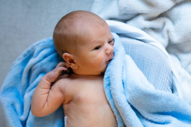 istock Newborn baby relaxing on soft blue blankets, resting peacefully 2200348149