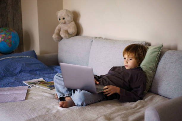 istock A boy studies with a laptop while sitting on the bed 2200350232