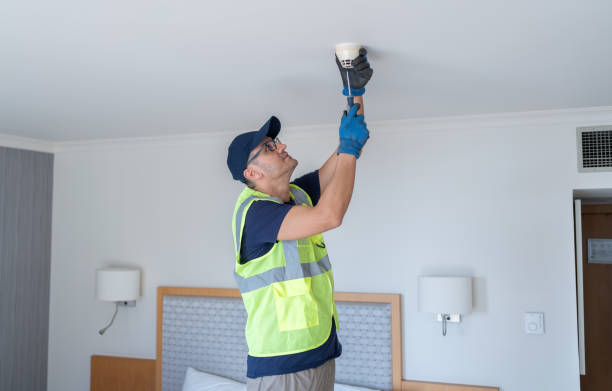 istock Worker Installing Smoke Detector At Hotel Room Ceiling 2200350623