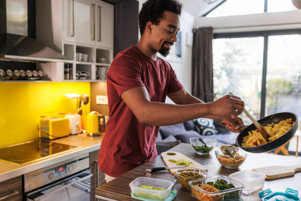 istock Man preparing healthy meals in kitchen for portioned lunch boxes 2200355644