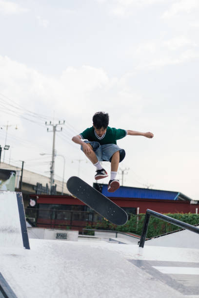 A father teaching his son how to do skateboarding tricks