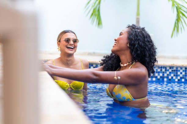istock Two friends enjoying the summer in a hostel swimming pool 2200356577