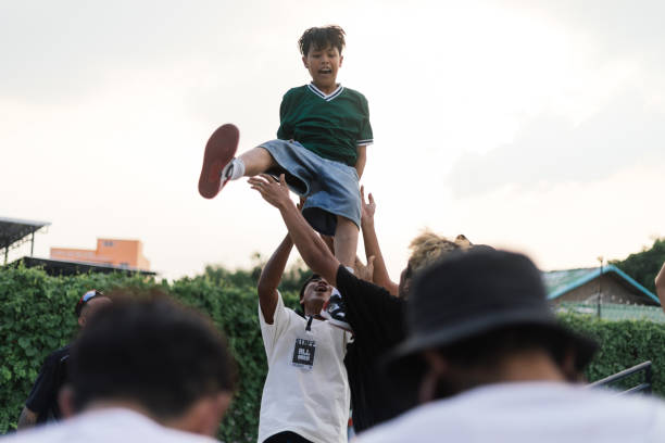 Man standing under bridge, arms outstretched, wearing oversized clothing, looking upward, low angle view emphasizing urban environment, representing Gen Z street culture
