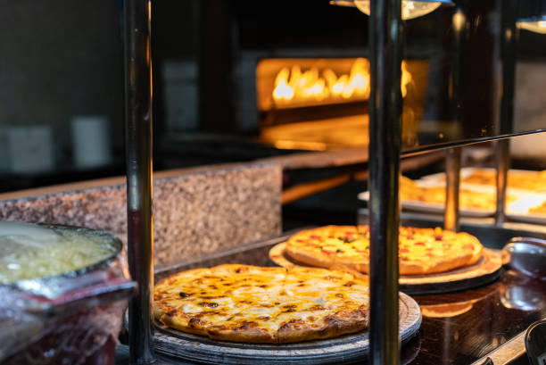 Delicious pizza being roasted in traditional oven at buffet