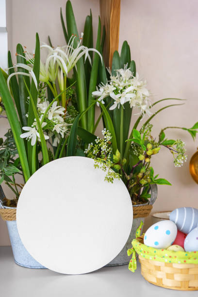Close up of homemade decorative basket with yellow delicate daffodils around the handler to put Easter eggs on the kitchen table.