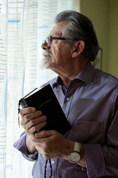 istock Elderly Man with Holy Bible in Prayer 2200363849