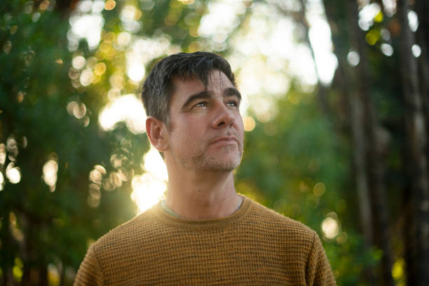 istock Relax, thinking and peace with man in park for adventure, reflection and environment. Resting, vision and wellness with mature person in nature reserve for calm, summer vacation and inspiration 2200365249