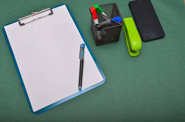 A person selects a marker from a drawer full of colorful stationery, holding a notepad with sticky notes.