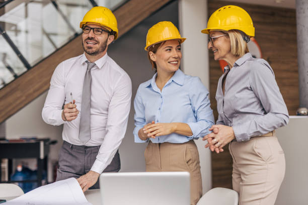 istock Architects and engineers wearing hard hats discussing a project 2200368576