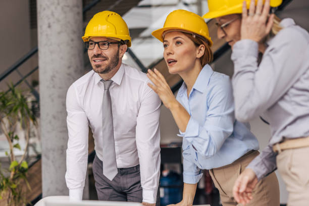 istock Architects and engineers wearing hard hats discussing a project 2200368591