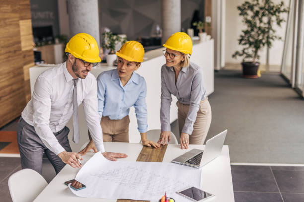 istock Architects reviewing blueprint in modern office: teamwork and collaboration 2200368713