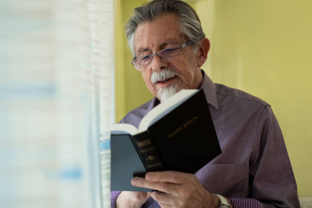 istock Elderly Man with Holy Bible in Prayer 2200369356