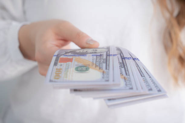istock Woman counting dollar bills 2200370803