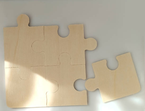 istock Puzzle piece assembly tabletop image of blank puzzle pieces minimalist environment close-up view creativity concept 2200371789