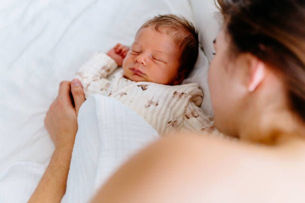 istock Close-up of newborn sleeping next to mother, tender connection 2200372749