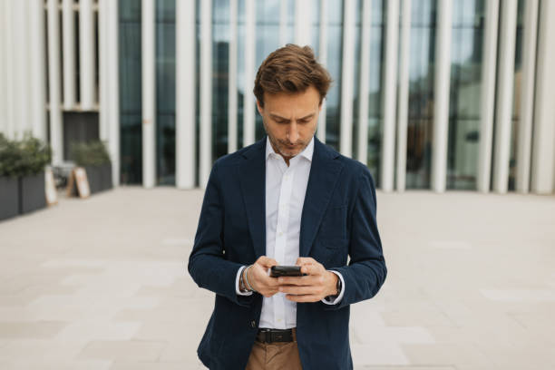 istock Man Engrossed in Phone at Stylish Location 2200374598