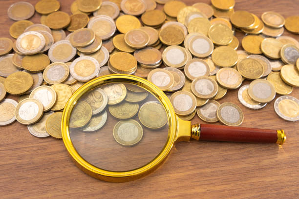 istock Pile of Coins with Magnifying Glass 2200376073