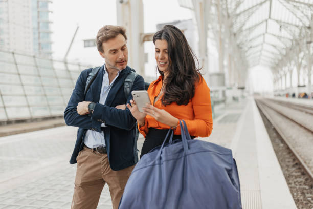 istock Checking Phone with a Friend at the Train Station 2200376891