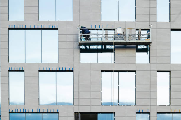 istock risky high building occupation work by male person on hanging platform balcony external skyscraper facade wall side 2200378800