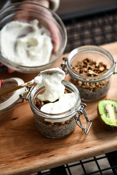 istock Female Adding Yogurt to Chia Pudding Jars For Balanced and Healthy Breakfast 2200379342