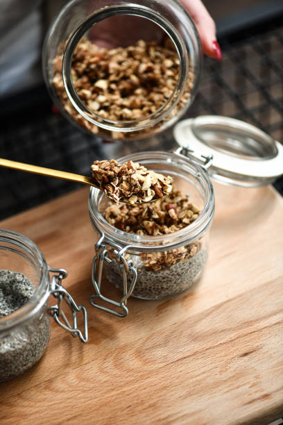 istock Female Creating Balanced Breakfast Sprinkling Homemade Granola on Chia Pudding 2200380122