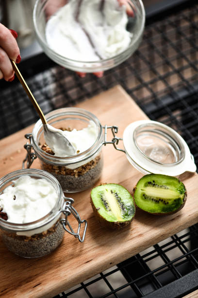 istock Female Adding Yogurt to Chia Pudding Jars for Extra Probiotic to Breakfast 2200380490