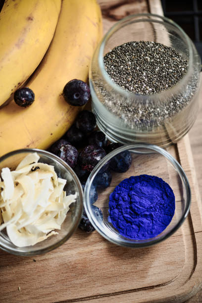 Chia Seeds Coconut Chips and Blue Spirulina in Glass Bowls Arranged on Wooden Tray
