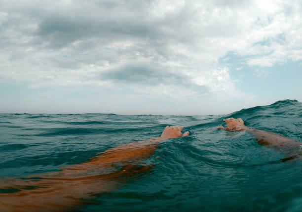 Personal perspective photo of a mid adult male swimming in the calm sea water