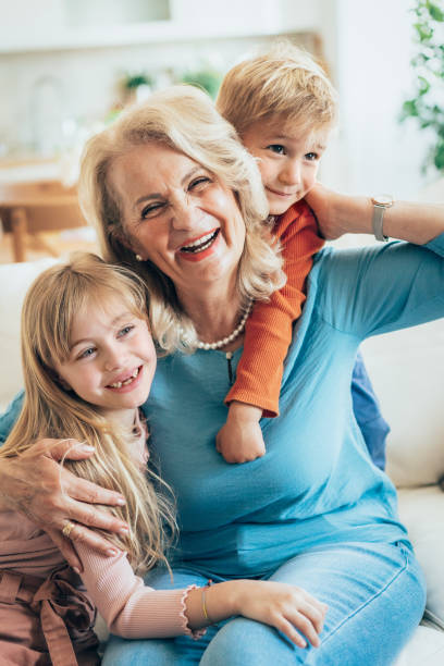Loving cute granddaughter hugging her grandmother. Wearing warm jackets. Happy family, remote location. Having good times with grandparent outdoors. Love, connection, bonding, healthy lifestyle