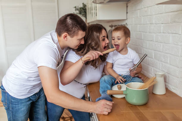istock Little boy with parents playing in the kitchen and cooking 2200383299