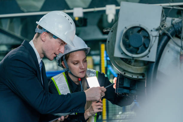 istock Engineers collaborate on machinery inspection at industrial facility during daytime hours 2200386436