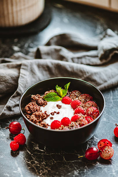 Delicious breakfast bowl with raspberries, gooseberries and chocolate chips
