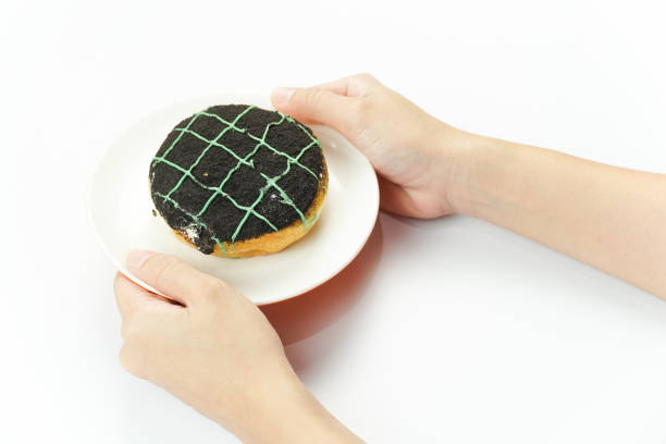 istock Hand Holding Chocolate Donut with Green Icing 2200387488