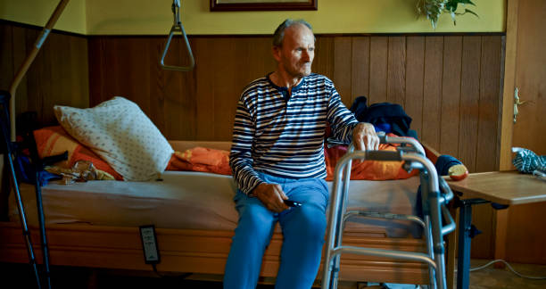 istock Caucasian Senior Man Sitting by Bed in Warm Indoor Setting 2200387502
