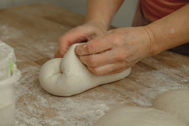 istock Mastering the art of bread making with skilled hands kneading the dough in a cozy kitchen setting on a warm afternoon 2200388426