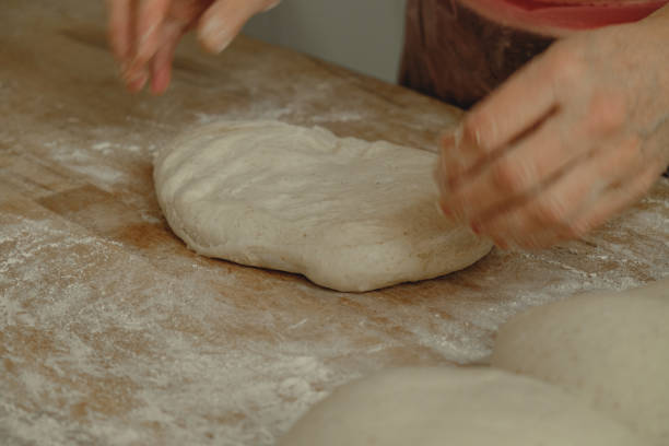 istock Kneading dough with care in a rustic kitchen, creating the perfect base for delicious homemade bread 2200388450