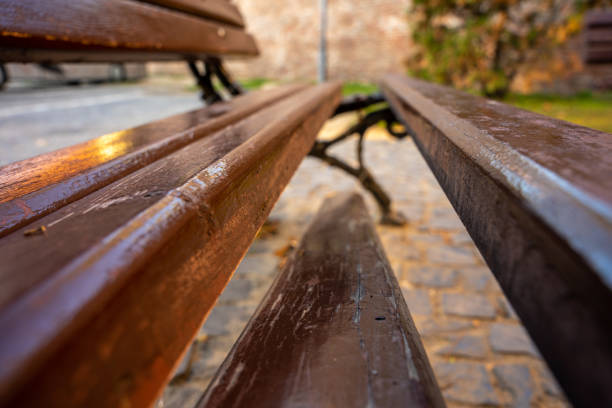 Sibiu, Romania - October 20, 2024: Weathered Wooden Bench with a Broken Plank in an Outdoor Setting.