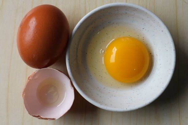 istock Cracked and whole chicken eggs on white background 2200389410