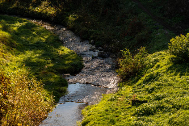 Hunedoara, Romania - October 20, 2024: Scenic River Flowing Beside the Historic Corvin Castle.