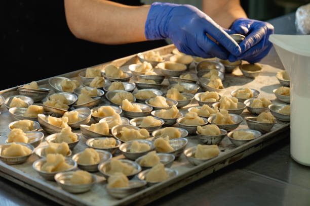 istock Delicate hands preparing exquisite dumplings in a bustling kitchen during a vibrant culinary event 2200391240