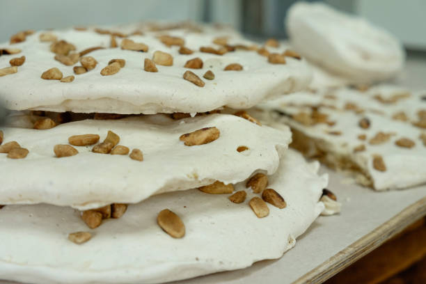 Delicious layers of meringue topped with crunchy nuts create a delightful dessert experience in a cozy kitchen during a sunny afternoon