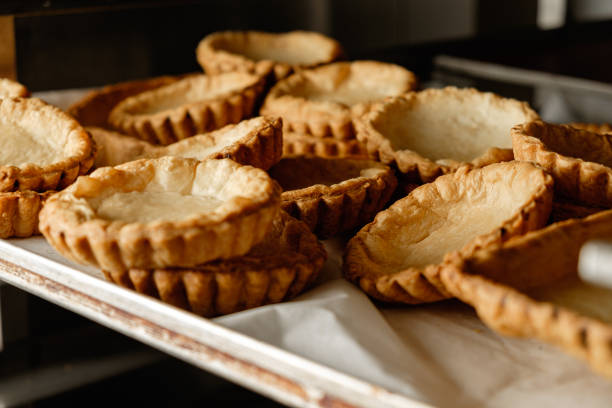 A warm, inviting kitchen filled with the aroma of freshly baked pastry shells resting on a baking tray, ready to be filled with delicious fillings for various desserts.