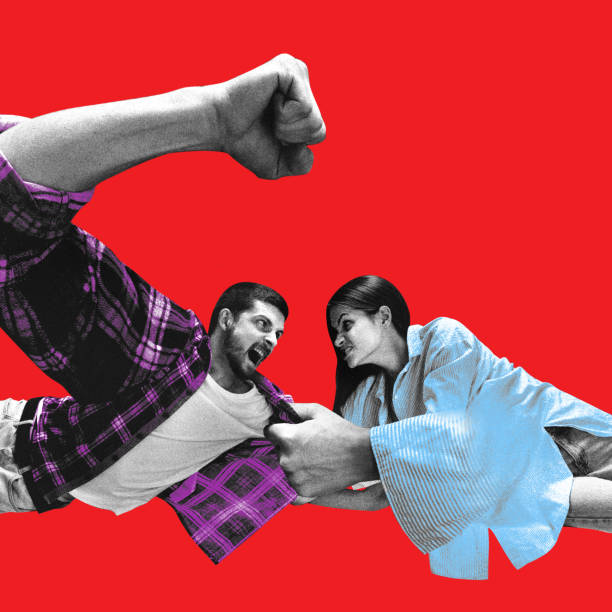 istock Man lunging forward with clenched fist while woman pulls his shirt, both engaged in intense confrontation against red background. 2200393553