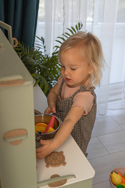 istock Child enjoys playtime in a beautifully arranged miniature kitchen setting 2200395871
