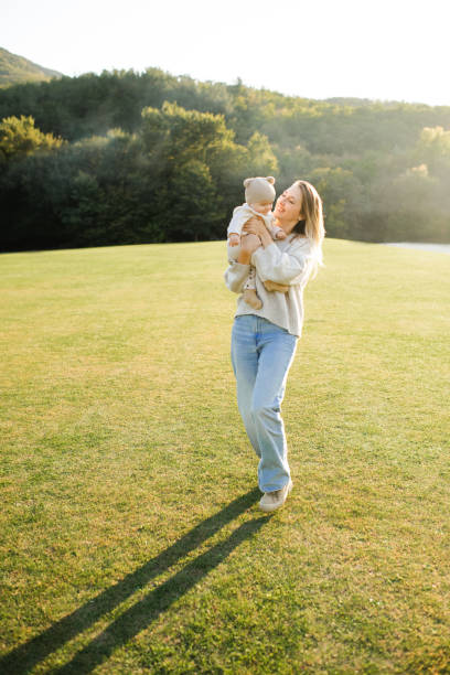 istock Woman holding baby boy in meadow 2200395949